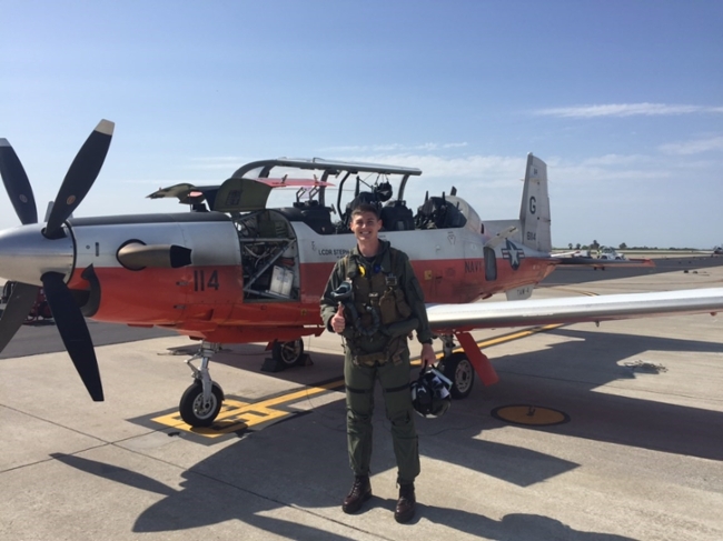 Bobby Macko '16, posing in front of a training aircraft at Naval Air Station Corpus Christi.